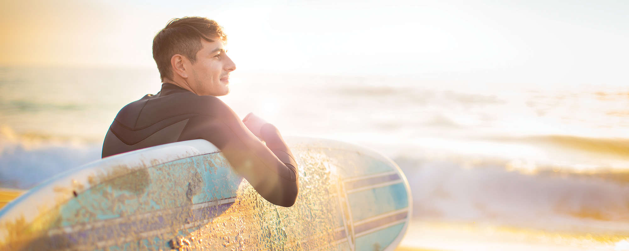 Man entering ocean with surfboard