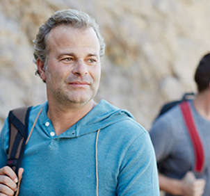 Older man in blue sweater hiking