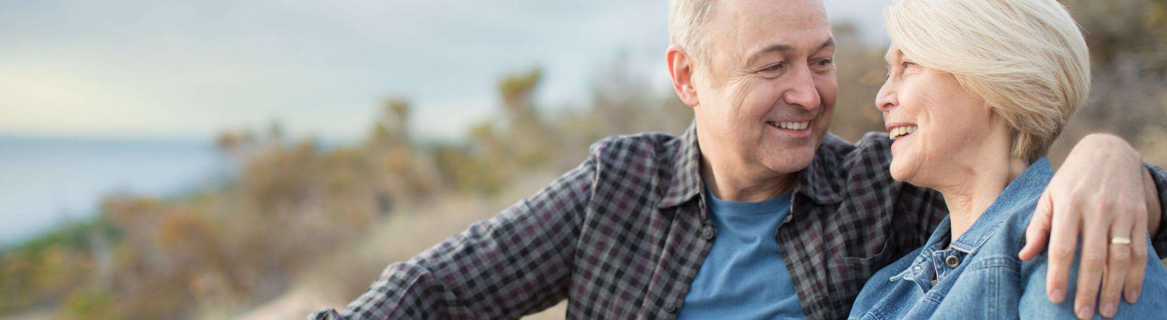 Older couple sitting on coastline