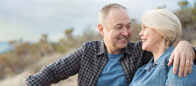 Older couple sitting on coastline