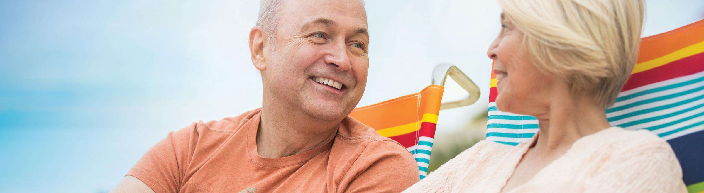 Older couple sitting on beach chairs desktop